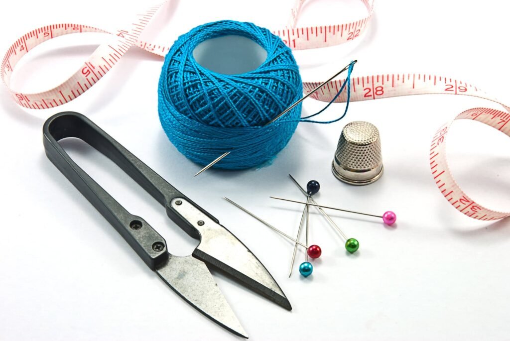 Thimble, needles and blue thread ball 